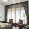 Grand bedroom with custom patterned drapes and sheers, showcasing expert curtain service for luxurious interiors.