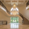 A breathtaking wide-angle shot of a double-height foyer with a perfectly scaled tiered chandelier.