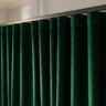 A close-up, angled shot of luxurious velvet or linen curtains.